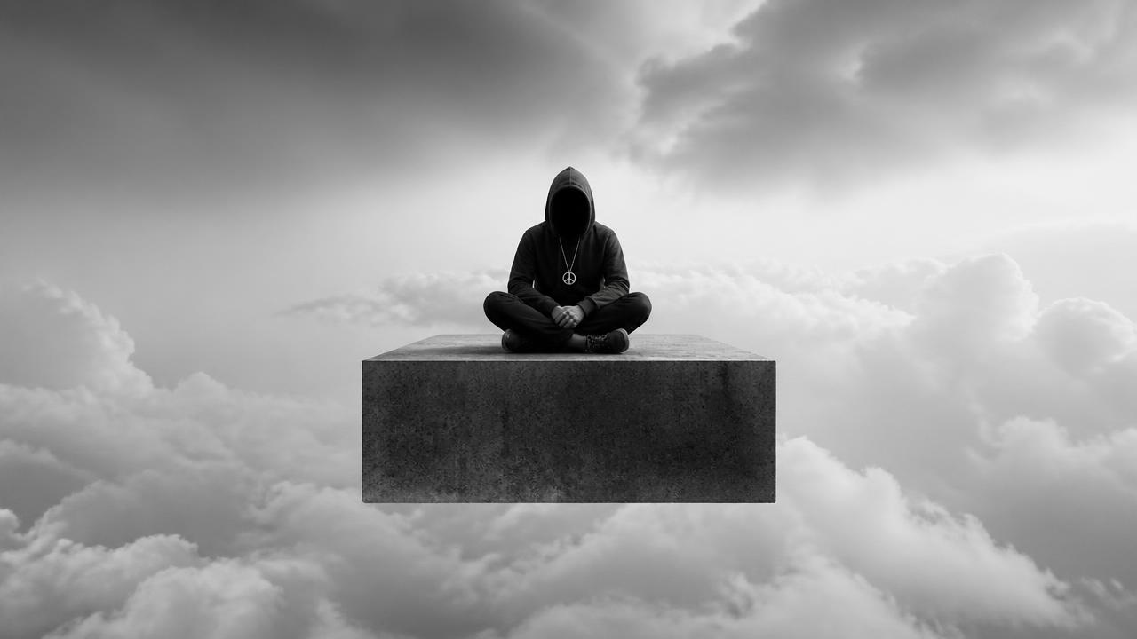 Black-and-white faceless figure seated in meditation on a concrete platform above clouds